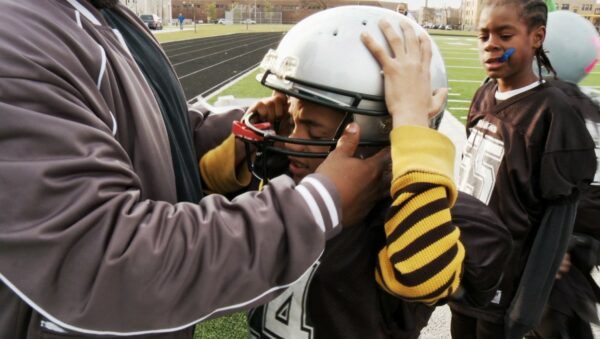 Donning a football helmet, an accessory in a sport known for its concussions, in “Head Games.” Credit Variance Films